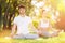 Couples Yoga, man and woman doing yoga exercises, meditate in sunny spring park. Yoga outdoor. Concept of healthy lifestyle and