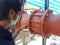 Coupling flange. The worker tightens the bolts on the Rubber Expansion Joint with hand for Cooling Tower.