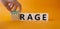 Courage and rage symbol. Businessman hand turnes wooden cubes and changes word Rage to Courage. Beautiful orange background.