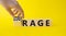 Courage and rage symbol. Businessman hand turnes wooden cubes and changes word Rage to Courage. Beautiful yellow background.