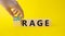 Courage and rage symbol. Businessman hand turnes wooden cubes and changes word Rage to Courage. Beautiful yellow background.