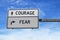 Courage versus fear. White two street signs with arrow on metal pole. Directional road. Crossroads Road Sign, Two Arrow. Blue sky