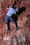 Courageous hispanic male climber carefully looking down