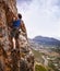 Courageous lead climber. Shot of a young woman clipping in a bolt while rock climbing.