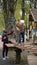 Courageous little boys climbing on a rope bridge with mom`s help