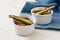 Courgette gratin with fried mini zuchini in small bowls, blue na