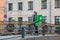 Courier in a branded green jacket, delivering orders by bike around the city