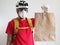 The courier cyclist wears face mask is delivering the paper bag. Delivery service during quarantine coronavirus