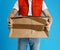Courier with damaged cardboard box on background, closeup. Poor quality delivery service