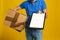 Courier with damaged cardboard box and clipboard on background, closeup. Poor quality delivery service