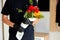 Courier, delivery man in black medical latex gloves safely delivers online purchases a bouquet of flower
