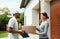 Courier Delivery. Man Delivering Package To Woman At Home