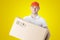 Courier from delivery service with parcel in hands on yellow background. Portrait of Caucasian male delivery service