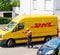 Courier enters DHL yellow delivery van after delivering the on time delivering package parcel