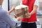 Courier giving damaged cardboard box to client in doorway. Poor quality delivery service