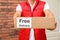 Courier holding parcel with sticker Free Delivery, closeup