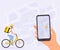 Courier man on bicycle with yellow parcel box on the back. Hand holding smartphone with finish point on city map.