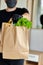 Courier man in black delivery box with food, contactless delivery