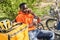 Courier man sitting at the bench and drinking coffee while chatting with his client