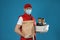 Courier in protective mask and gloves holding order on background. Food delivery service during coronavirus quarantine