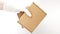 Courier`s hands in latex white medical gloves deliver parcels in brown cardboard boxes to the door during the epidemic of