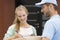 Courier and smiling woman signing receipt on box