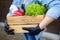 Courier or volunteer wearing medical face mask delivering shopping during coronavirus quarantine. Woman customer receiving online