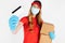 Courier, wearing medical rubber gloves and a medical mask, holds cardboard boxes and a credit card on a white background. Fast