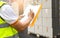 Courier worker holding clipboard his doing inventory management cargo boxes. Checking stock. shipment boxes. Warehousing storage.