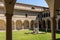 Courtyard with decorated columns, arches and green lawn of old Franciscan friars cloister near the Dante`s Tomb and Basilica of