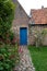 Courtyard garden with blue door at 15th century Jerusalem Church Jeruzalemkerk, Bruges / Brugge, Belgium.