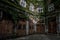 Courtyard Of A Historic Building With Wooden Doors And Ivy Overgrown Walls