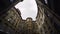 Courtyard of old round building in city. Action. Bottom view of old house with courtyard well on background of sky. Old