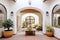 courtyard with white walls, arched entry, and potted plants