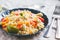 Couscous salad with fresh red and yellow bell peppers, avocado, tomatoes and lime