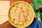 Couscous, spices and tomato tabbouleh salad with rice bread in a yellow plate on a wooden background. Traditional oriental salad,