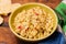 Couscous, spices and tomato tabbouleh salad with rice bread in a yellow plate on a wooden background. Traditional oriental salad,