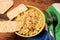 Couscous, spices and tomato tabbouleh salad with rice bread in a yellow plate on a wooden background. Traditional oriental salad,