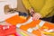 Couturier sews a dress in the studio. Fashion designer making a pattern on piece of tissue. Sewing machine is standing on the tabl