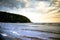 Cove with sunbathers and tourists on the beach on beautiful picturesque day with mountains