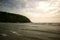 Cove with sunbathers and tourists on the beach on beautiful picturesque day with mountains