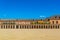 Covered arcade of royal palace at Aranjuez behind fence, Spain