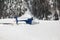 A covered blue helicopter in the snow covered landscape and mountains in the alps switzerland in winter