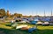 Covered rowboats and sailing boats ashore with harbor in the background