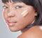 It covers me in all the right places. Studio shot of an attractive young woman applying different shades of foundation