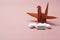 Covid-19 antivirus white drugs Remdesivir text symbol and blurred Japanese red bird origami paper on a pink rose gold