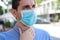 COVID-19 Close Up Man Wearing Surgical Mask with Sore Throat Outdoor. Portrait of Man with Face Mask Against SARS-CoV-2 Suffering