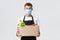 Covid-19, contactless shopping and groceries delivery concept. Handsome friendly salesman, courier in medical mask