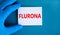 Covid-19 corona and flu flurona symbol. Hand in blue glove with white card. The concept word Flurona. Stethoscope. Medical and