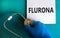 Covid-19 corona and flu flurona symbol. Hand in blue glove with white note. The concept word Flurona. Stethoscope. Medical and